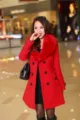 Vue détaillée d'un manteau de laine rouge pour femme avec col en fourrure et double boutonnage. - M / Rouge