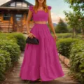 Detaillierte Ansicht des pinken rüschen Crop Tops und langen Stufenrocks im Garten. - S / Set / Fuchsia