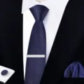 Vue détaillée d'une cravate bleu marine rayée avec pince et boutons de manchette. - Style à nouer soi-même | Version étroite 6 cm | W6A6003-1