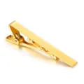 Golden metal tie clip detail, elegant men's polished accessory close-up display. - Gold