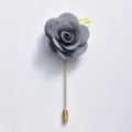 Broche camélia en tissu gris avec tige et feuille dorées, élégant bijou pour mariage. - Gris