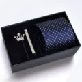 Close-up detail of the men's blue patterned tie set with elegant silver brooch and clip. - KHVA8009-1A