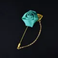 Elegant teal fabric rose lapel pin with gold chain and pin, perfect for wedding suit decor. - Lake Blue