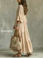 Detailansicht eines vintage beigen gestuften Langarmkleides mit ethnischen Handtasche. - Aprikose