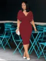 Elegant burgundy V-neck short sleeve midi dress with pearls worn in outdoor cafe scene. - S / Dresses / Burgundy