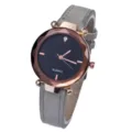 Detailed view of women fashion quartz watch with grey leather strap and faceted bezel. - Gray