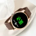 Detailed view of the round LED touch watch with brown strap and green digital display. - 23x2 / Coffee