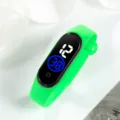 Primo piano dettagliato del vivace cinturino in silicone verde e dello schermo LED digitale. - 23x2 / Verde erba