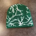 Primo piano di berretto in maglia verde con motivo jacquard astratto bianco streetwear. - Taglia M / Verde