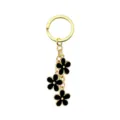 Portachiavi in metallo dorato con tre eleganti ciondoli a fiore in smalto nero per le donne. - Nero