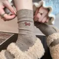 Detalle de calcetines de lana acogedores con bonito motivo de perrito y textura cálida. - Café Claro