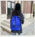 Detailansicht des blauen Kordelzug-Rucksacks mit klassischen drei Streifen und viel Stauraum. - Blau
