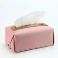 Primer plano de caja de pañuelos de cuero rosa con detalle dorado y textura fina. - Rosa