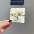 Détail d'élastique à cheveux en tissu à pois verts, parfait pour le style quotidien des filles. - Élastique à Cheveux Fleur Verte