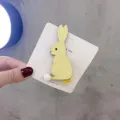 Detailansicht niedlicher Kaninchen Haarklammer, Glitzerhase mit Plüschschwanz auf Karte. - Gelbes Kaninchen