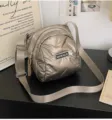 Stylische metallische Puffer-Umhängetasche mit gestepptem Design und breitem Gurt. - Champagnergold