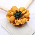 Handgemachte Stoffblume DIY Haarschmuck mit leuchtend gelben Blättern und dunklem Zentrum. - Haarspangen-Stil / Gold