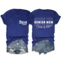 Senior mom class of 2027 t-shirt paired with denim shorts detail view showing front and back prints. - S / Tops / Army Green (White Font)