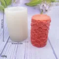 Cylindrical silicone candle mold with floral embossed finished candle, 12.7cm size, product detail shot. - Flower Candle Molds