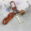 Porte-clés lettre L dorée chaîne marron pendentif sac, accessoire élégant en alliage. - Lettre L