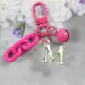 Porte-clés en alliage rose avec pendentif lettre M dorée et breloque de sac élégante. - Lettre M