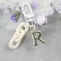 Porte-clés lettre R en alliage doré avec chaîne blanche et clochette violette. - Lettre R