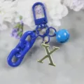 Porte-clés chaîne en acrylique bleu avec pendentif lettre X dorée et breloque cloche. - Lettre X