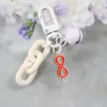 Stijlvolle rode sleutelhanger met een 8-vormige hanger, witte ketting en paarse bel. - Stijl 4