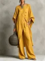 Nahaufnahme des eleganten senfgelben asymmetrischen Leinentunika und Hosen Outfits. - Gelb