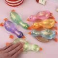 Glitzerndes Enten-Squishy-Spielzeug beim Drücken, um die weiche Textur zu zeigen - Enten-Squishy / Rosa Ente
