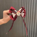 Charmante pince à cheveux de Noël pour enfants avec joli nœud et motif de père Noël festif. - Rose