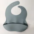 Dusty blue silicone baby bib, waterproof toddler feeding pocket with adjustable buttons. - Blue