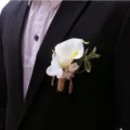 Close up detail of elegant white calla lily groom boutonniere with twine wrapped stem for wedding. - White