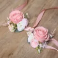 Primo piano dettagliato di fiori da polso in rose artificiali rosa con nastro elegante. - Corsage da polso