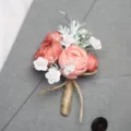 Elegante stoffen bruiloft boutonnière koraal camelia corsage met jute stengel voor pak bruidegom. - Corsage / Lichtrood