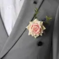 Elegante botonera de rosa artificial con hojas verdes para el novio y los padrinos de boda. - 8x12cm / Estilo 3