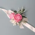 Elegante roze ranonkel polsbloem corsage voor een huwelijksfeest en formele variant - Polscorsage / Dieproze