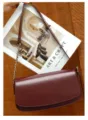Dettaglio borsa a tracolla in pelle bordeaux con catena chic e raffinato design a patta. - Borgogna
