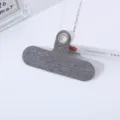 Primer plano detallado de una lengüeta de tela gris para cordón de teléfono con ojal metálico. - Gris