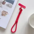 Primer plano de la correa de muñeca roja para teléfono con hebilla ajustable y almohadilla. - Rojo Con Parche