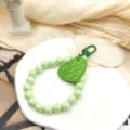 Light green pearl beaded wrist strap phone charm with a cute green heart pendant for women. - Grass Green