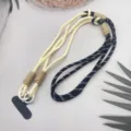 Gros plan de détail sur la lanière de téléphone portable réglable avec corde tressée bicolore. - Motif fin noir et blanc avec beige et patch