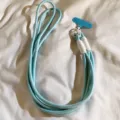 Vista di dettaglio del cordino per telefono intrecciato azzurro con tracolla e connettore. - Linguetta Blu / Celeste