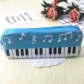 Vista detallada de un estuche escolar azul de lona con teclas de piano y notas musicales. - Azul claro