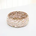 Hand-woven round storage basket detail, natural straw and white cord intertwined design. - White Striped Cattail Basket