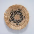 Detailed view of bohemian round straw woven wall hanging with black spiral pattern and fringe. - 35cm Raffia Tassel with Black Plane Flower Spiral (25cm Center)