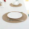 Detailed view of a round woven jute placemat on a clean white table with tableware, perfect for dining. - Round 35cm