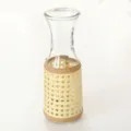 Close-up detail of a vintage woven rattan glass bottle sleeve, perfect home decor. - Style 1 (with Bottle)