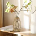 Close-up detail of a creative glass vase wrapped in natural straw woven sleeve for home decor. - Small Grass Flower Milk Bottle With Bottle