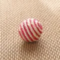 Closeup of a red and white woven ball detail, handmade straw craft for decoration. - Sisal Red Striped Ball
